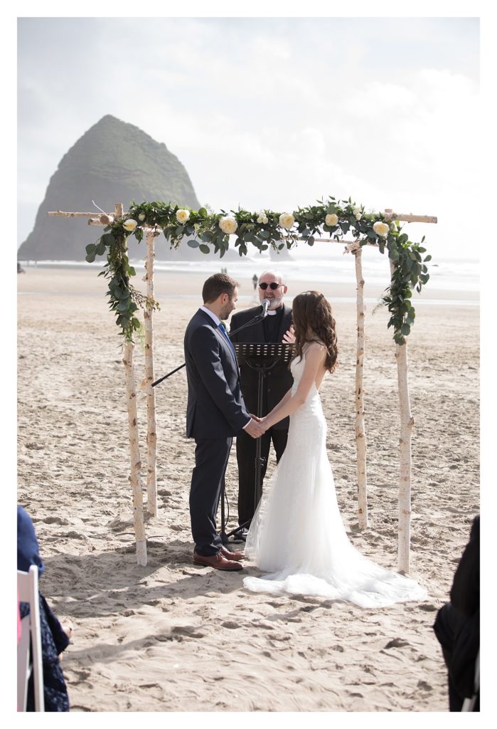 couple exchanging vowes in front of Haystack Rock